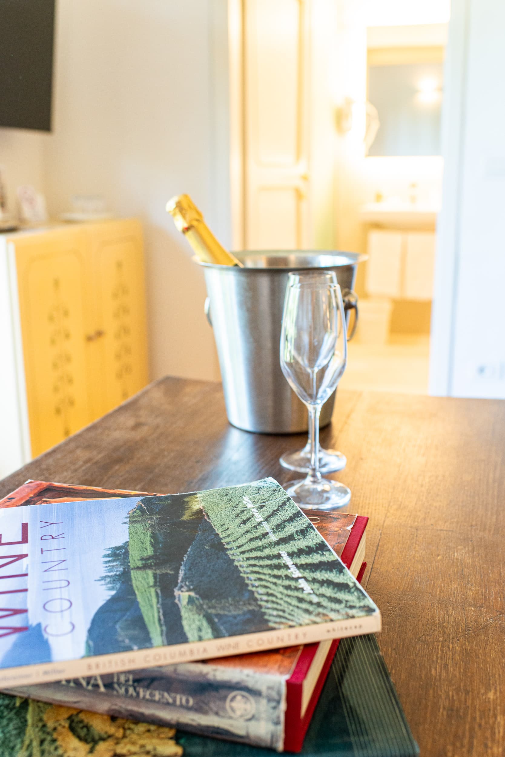 Elegante tavolo in legno con calici e secchiello per champagne in un resort di lusso a Villa I Barronci, Chianti.