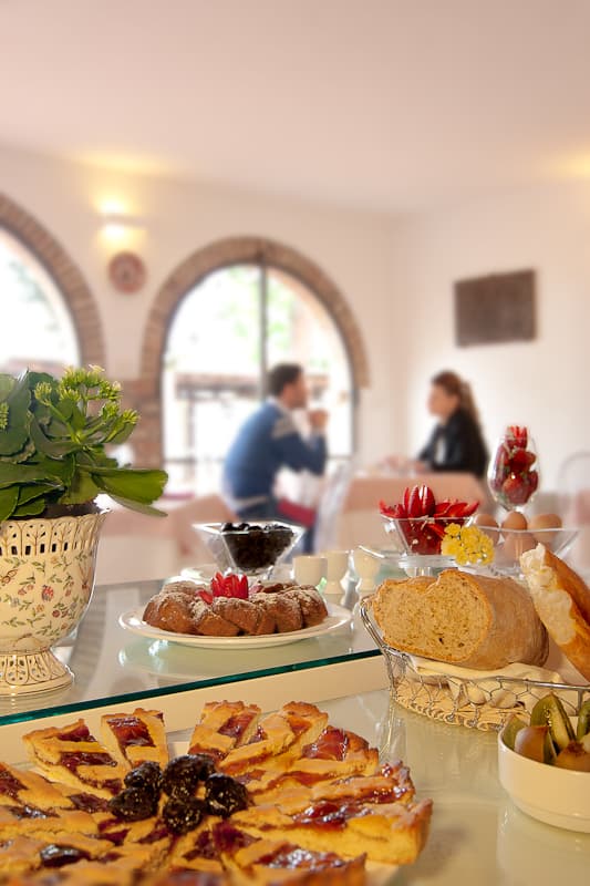 Colazione gourmet in villa nel Chianti, con dolci tipici e coppette di frutta fresca al resort di lusso.