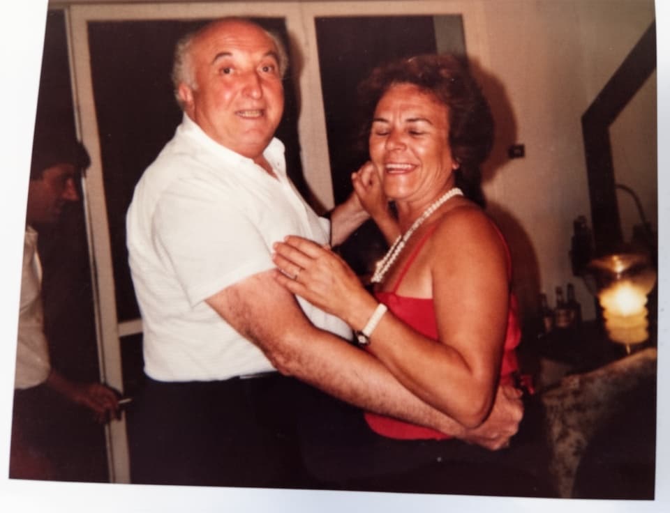 Due persone sorridenti danzano insieme in un ambiente accogliente di Villa I Barronci, resort di lusso nel Chianti.